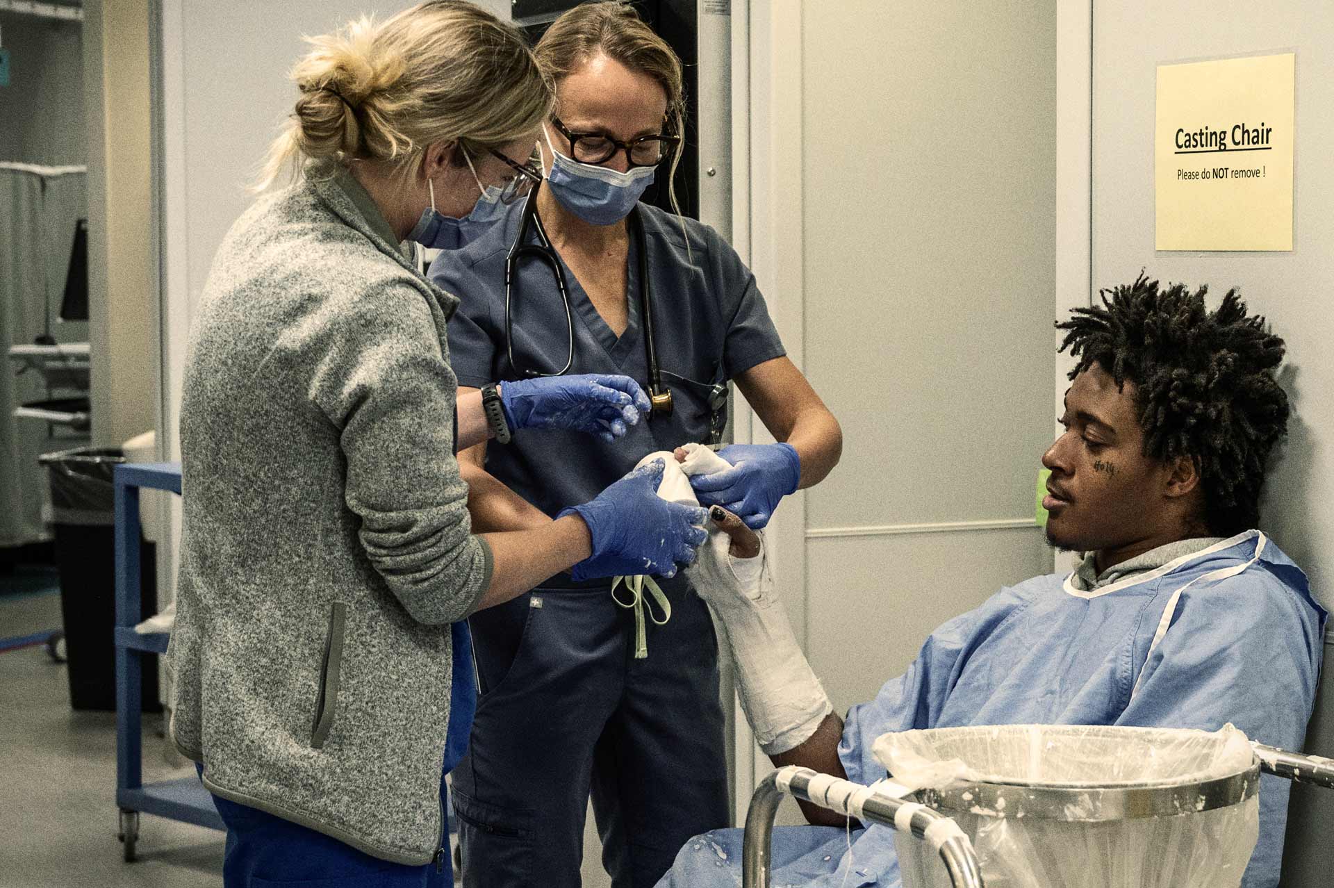 Two nurses tending to a patients arm.