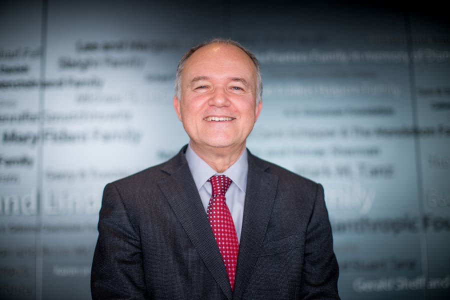 Dr. Donald Weaver, a Senior Scientist and the Krembil Chair for Drug Discovery Research related to Alzheimer's Disease, smiling in front of a glass window at the Krembil Research Institute.