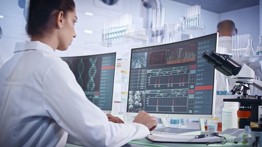Researcher at a computer wearing a white lab coat