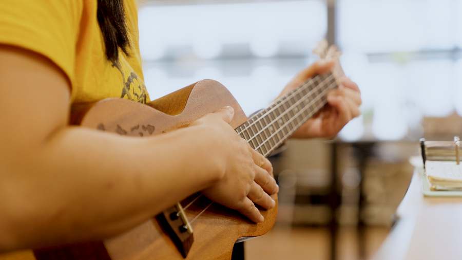 Vanessa Ong playing music while wearing her TRI Hards t-shirt.