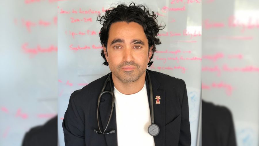 Dr. Andrew Boozary in front of a whiteboard.
