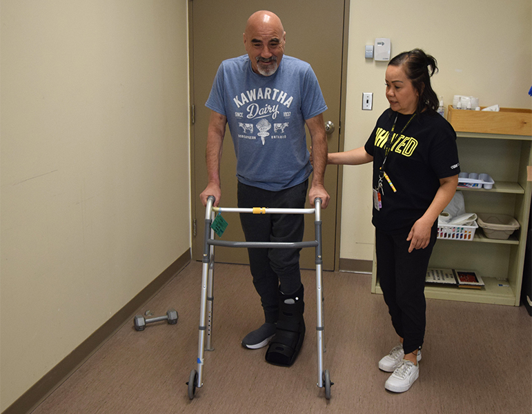 Nick D'Elia, (L), a patient who is on dialysis and recovering from surgery, does walking exercises with Jean Dilag, a physiotherapist assistant at UHN's Toronto Rehab, Bickle Centre, where for nearly two decades she has supported patients with complex care needs. (Photo: UHN)